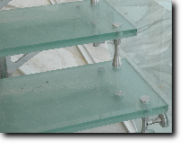 Dettaglio di scala con struttura portante in acciaio inox, e gradini di legno massiccio.