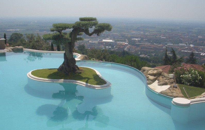 Bordo piscina con vetri curvi strutturali. Bordo piscina in vetro incastrato alla base.