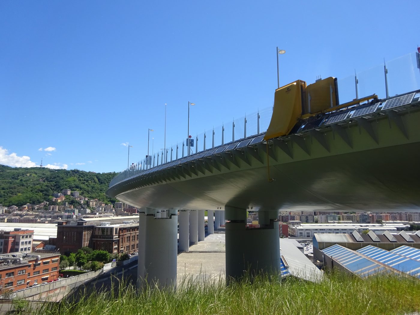 Vista d'insieme del nuovo Ponte San Giorgio a Genova sui piloni, con pannelli fotovoltaici e parapetto in vetro lungo tutto l'impalcato