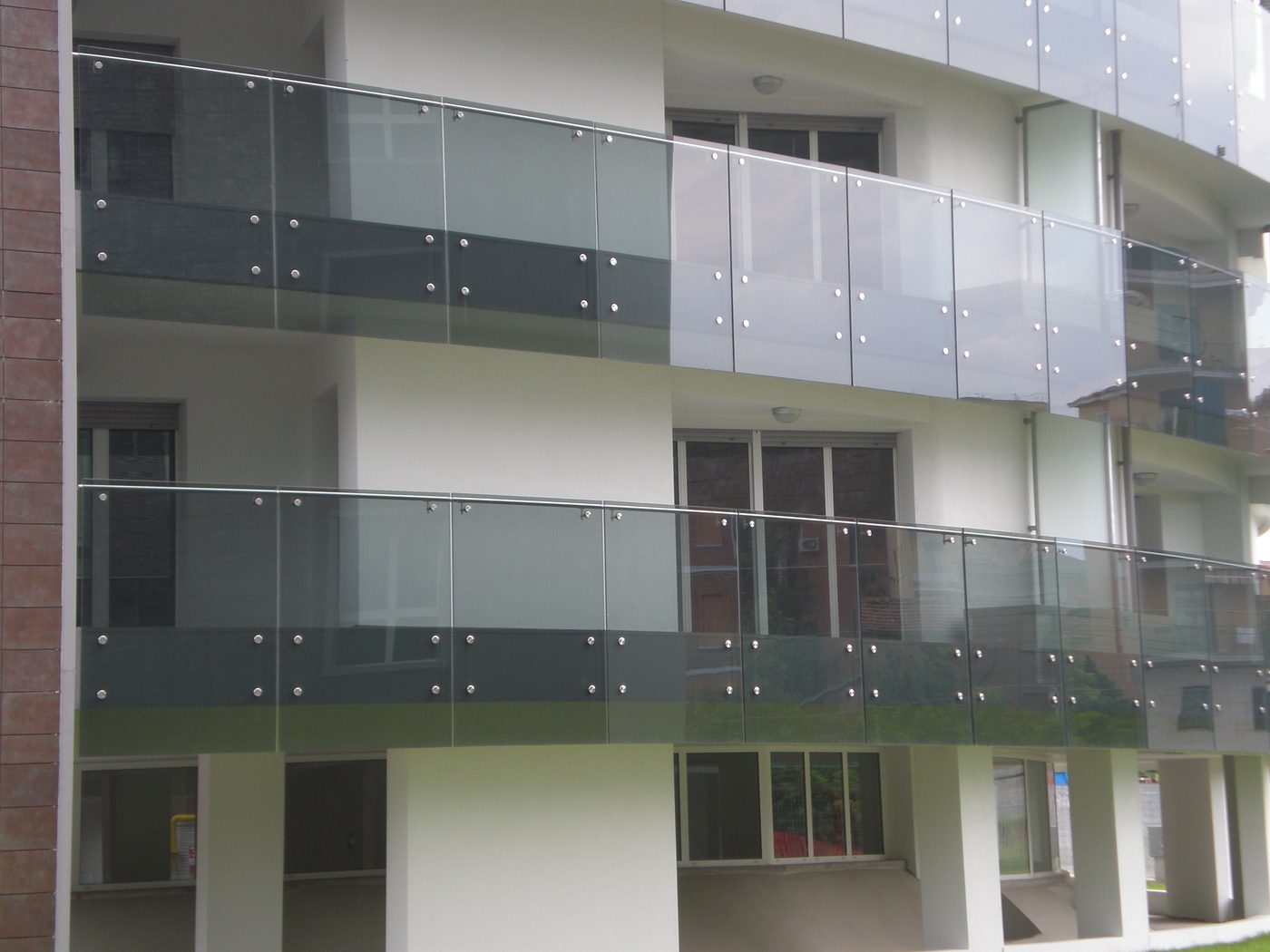 Balaustre in vetro a fissaggio puntuale sui balconi di edifici residenziali a Bologna