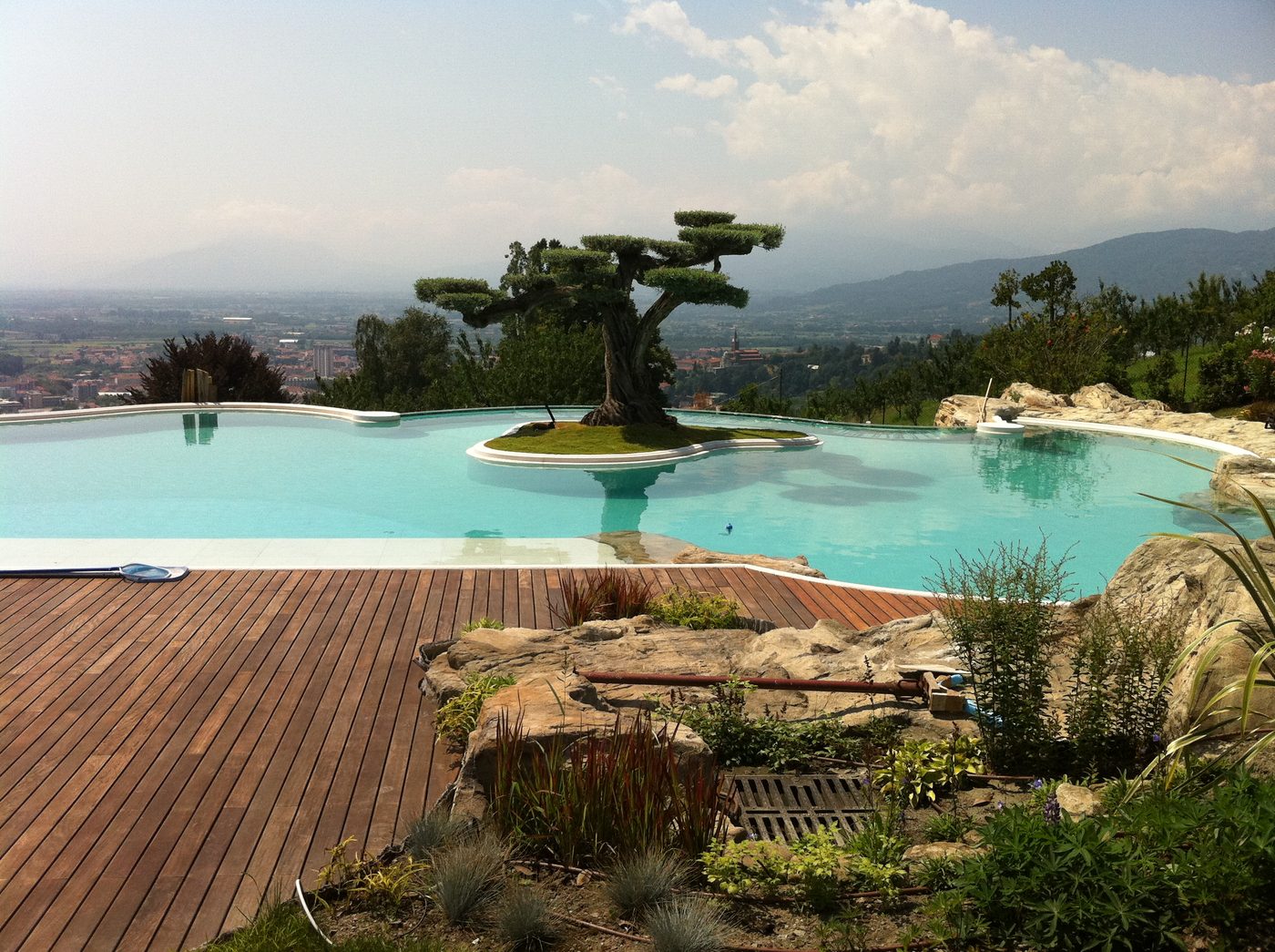Piscina a sbalzo panoramica sulle colline torinesi con bordo in vetro stratificato, vista sulla vallata