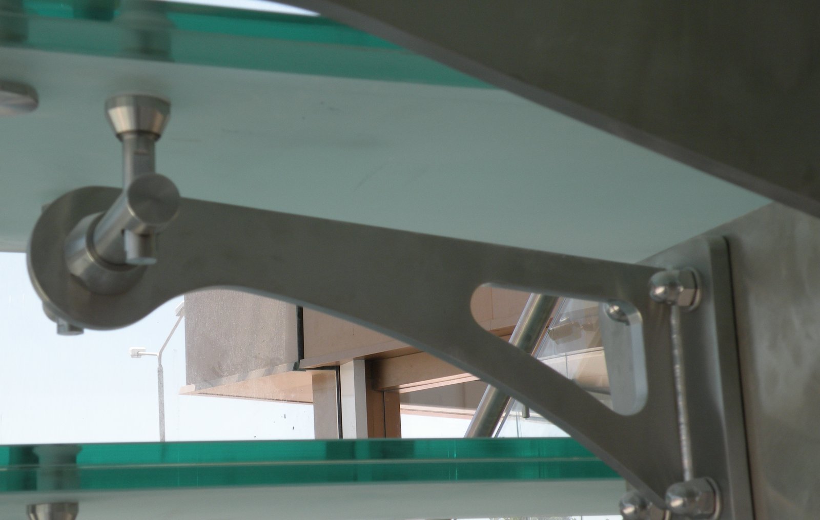 Dettaglio di una singola staffa in acciaio inox arcuata e alleggerita, con profilo scultoreo, scala di Malta